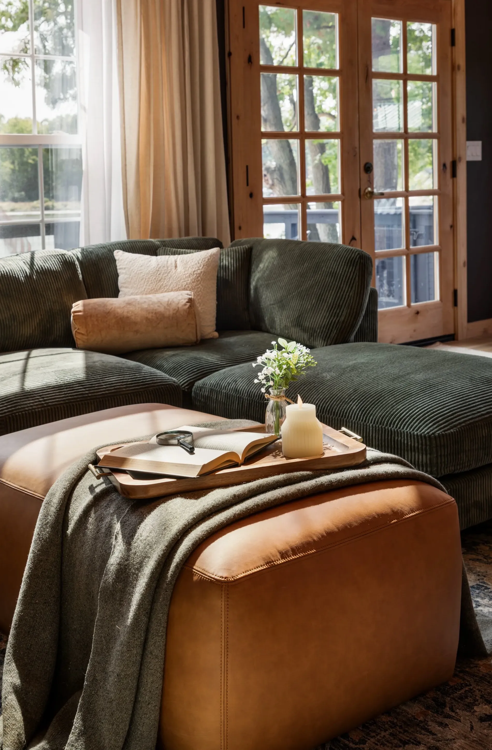 Corduroy sofa and leather ottoman in a Studio Host interior