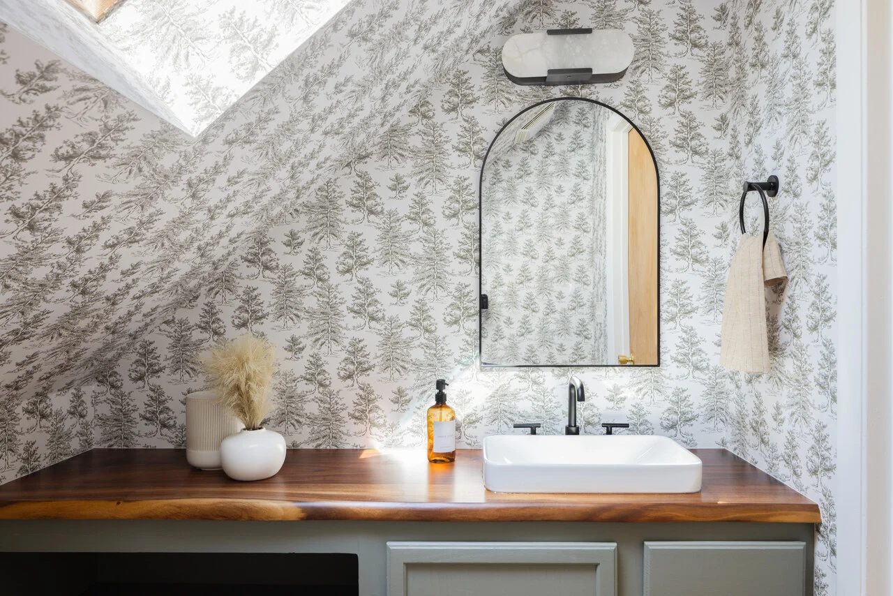 Photograph of the powder room, papered in a soft woodland toile, built